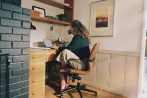 Profissional demonstrando postura no home office correta em mesa de trabalho